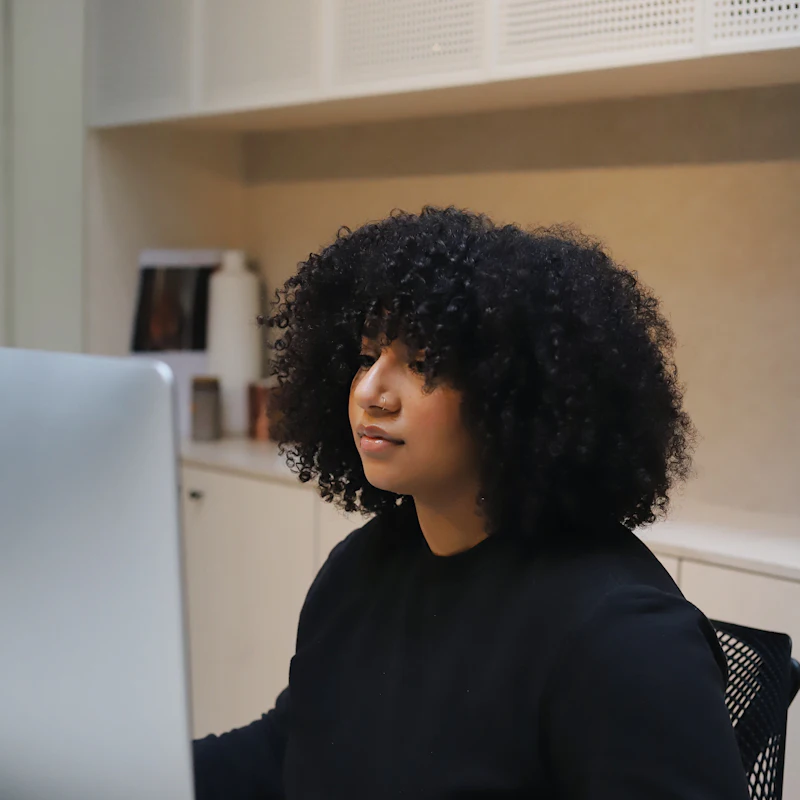 Mujer trabajando frente a su computadora en una oficina